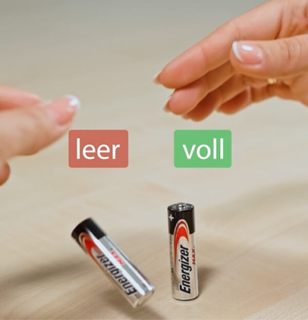 Eine leere und eine volle AA Batterie. 