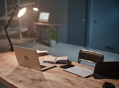 Eine Tischleuchte beleuchtet einen Büro-Schreibtisch