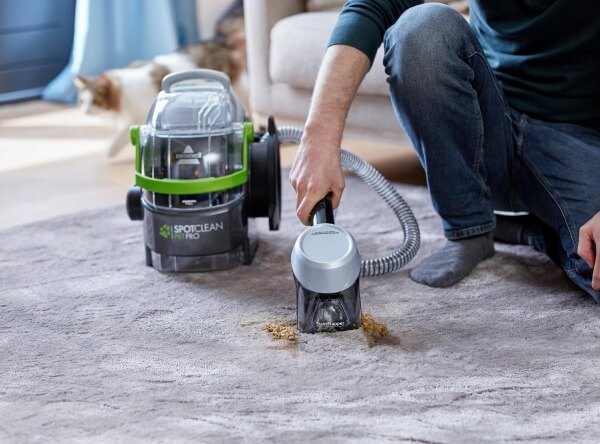 Person reinigt Teppich mit Bissell Waschsauger Spotclean Pet Pro