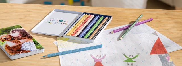 Faber-Castell Farbstifte liegen neben einer Kinderzeichnung