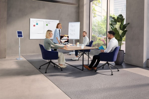 Ein Team benutzt bei einem Meeting ein Flipchart und ein Whiteboard