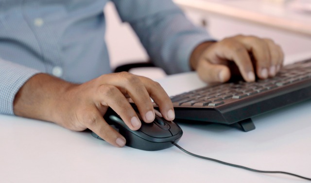 Eine Person benutzt eine Maus und Tastatur