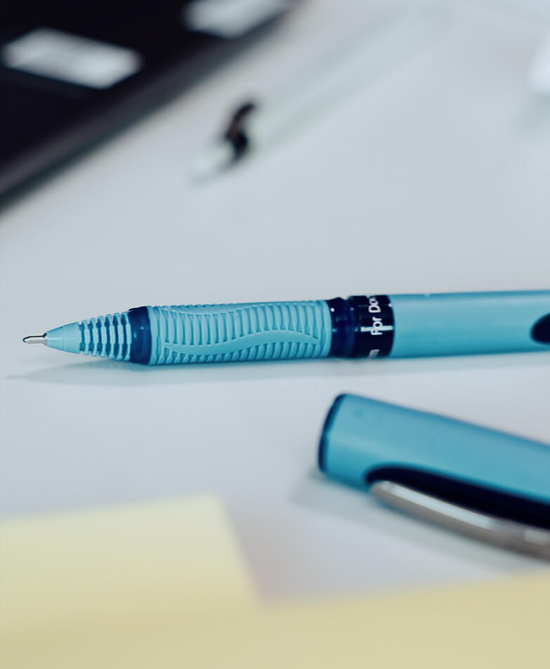 Schneider One Hybrid Rollerball liegt auf Schreibtisch