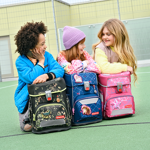 Schulkinder laufen mit ihren Schultheks zur Schule