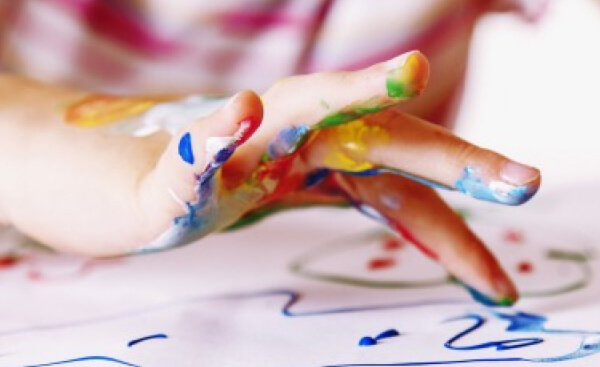 Kind malt mit Fingerfarben