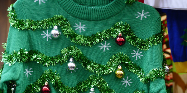 Grüner Weihnachtspullover mit Weihnachtskugeln