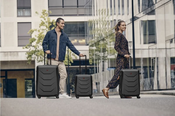 Frau und Mann laufen mit Wenger Prymo Carry-on Koffern