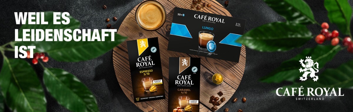 Café Royal Kaffee liegt auf einem Holzbrett umgeben von Kaffeebohnen
