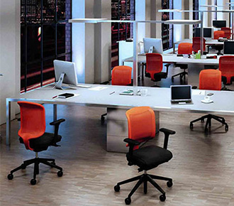 Mehrere Bürostühle Giroflex 434 mit schwarzer Sitzfläche und rotem Netzrücken in einem grossen Büro.