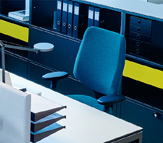 Ein grauer Bürostohl Giroflex 545 hinter einem Schreibtisch.