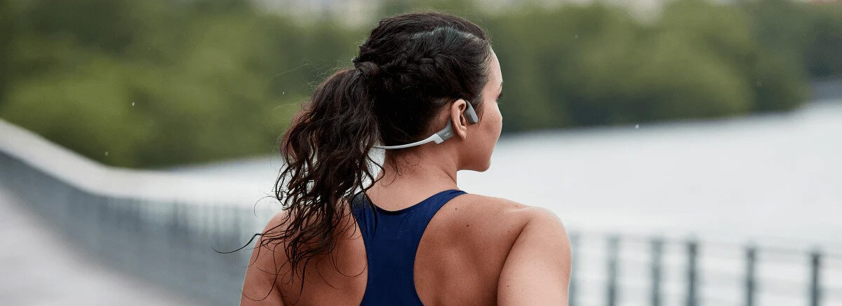 Frau joggt mit Shokz OpenRun Kopfhörern