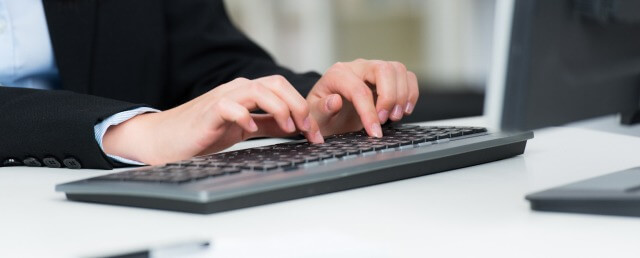 Eine Frau tippt im Büro auf einer PC-Tastatur